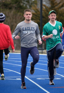 Junior Kyle Pfhol, who's organizing a Father's Day run to benefit local cancer patients, warms up before a practice with track teammate Chris Markham '17. Photo by Norm Shafer.