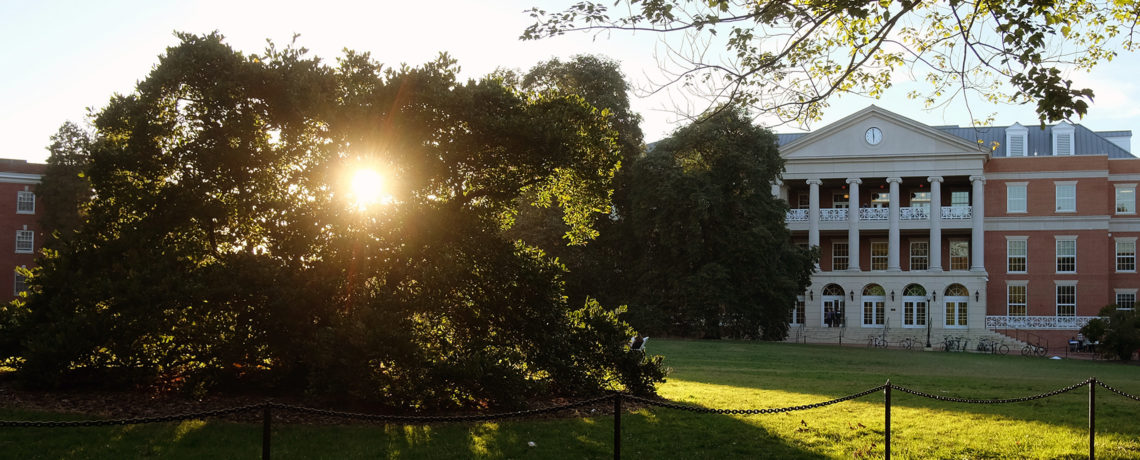 Sun shining through trees in front of the University Center