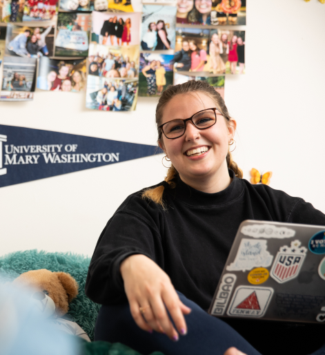 2 students hanging out in their dorm smiling