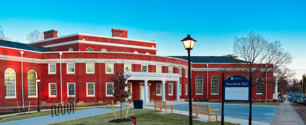 The image is of a scenic view of Secobeck Hall at the UMW campus on a clear blue skyed sunset.