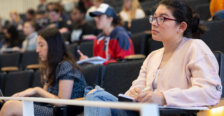 A classroom full of students looking at the professor.