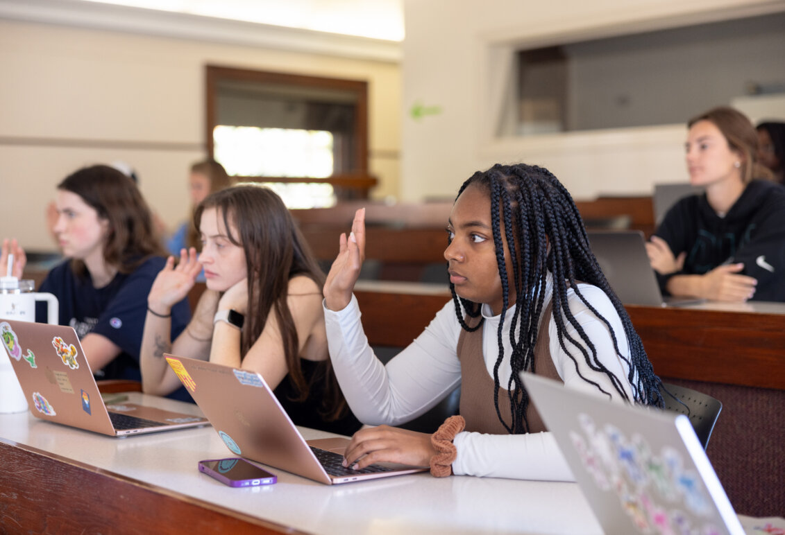 A girl raising her hand in class.