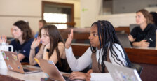 A girl raising her hand in class.