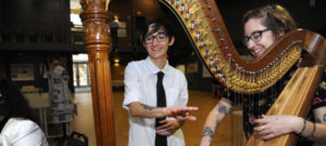 Music students playing a harp