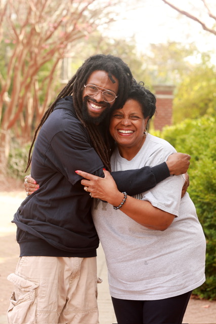 A student and parent lovingly embrace on campus.