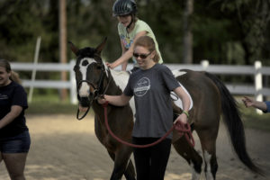 UMW sophomore Elizabeth Finto volunteers on a recent Tuesday night with the therapeutic horseback riding program at Hazelwild Farm. Photo by Reza A. Marvashti.