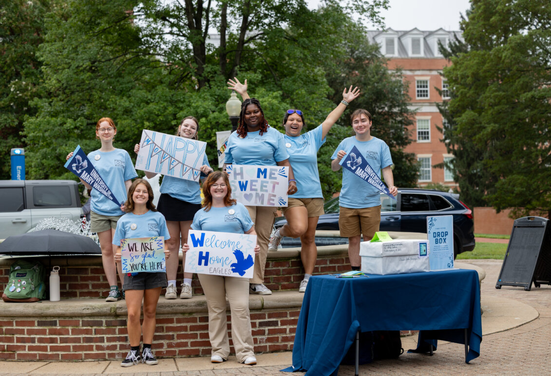 Group of students holding welcome signs during move-in day