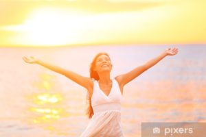 Woman with her arms out wide looking up