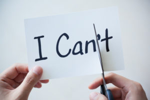 The words I can't on paper with a scissor cutting through the words to reveal "I can"