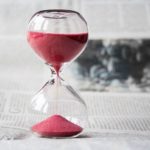 hourglass with red sand passing through