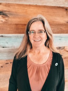 woman standing against wall smiling