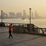 person dancing along a boardwalk near water