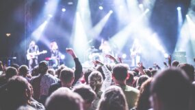 people in a crowd watching a band play on stage.