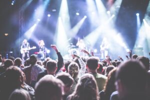 people in a crowd watching a band play on stage.