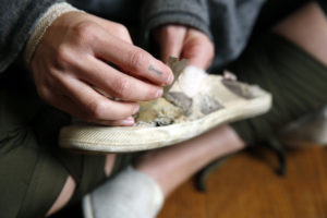 Anna Prezioso '09 rips the seams from a shoe she wore as a student at the University of Mary Washington, where she majored in studio art. She returns this week for an alumni exhibition that opens Thursday in duPont Gallery.