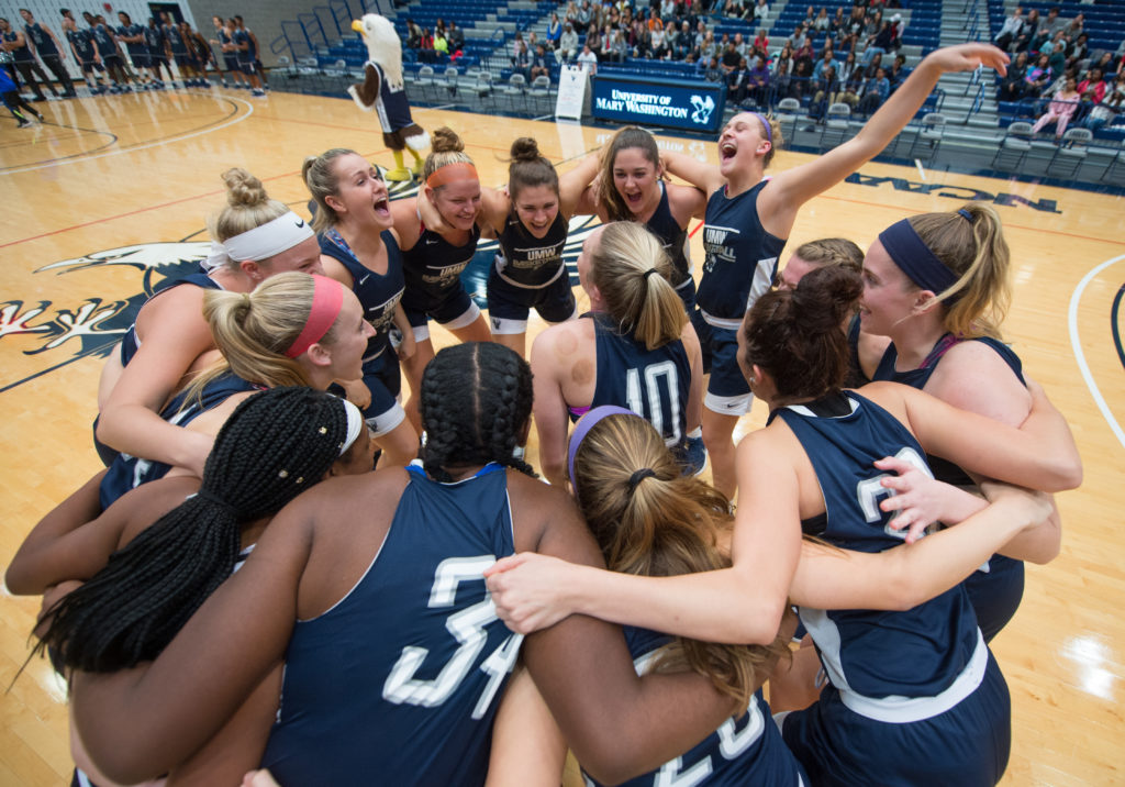 UMW women’s basketball – CAC finalists – shares a celebratory moment in the William M. Anderson Center’s Ron Rosner Arena.