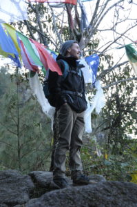 UMW junior Jarrett Ashby stands in front of prayer flags at the Chumik Jangchub temple in Nepal. Photo by Dan Hirshberg.