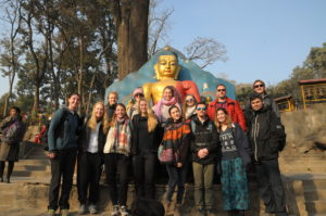 Posing with the Buddha before ascending the long stairway to Swayambhu Stupa in Nepal. Photo by Dan Hirshberg.