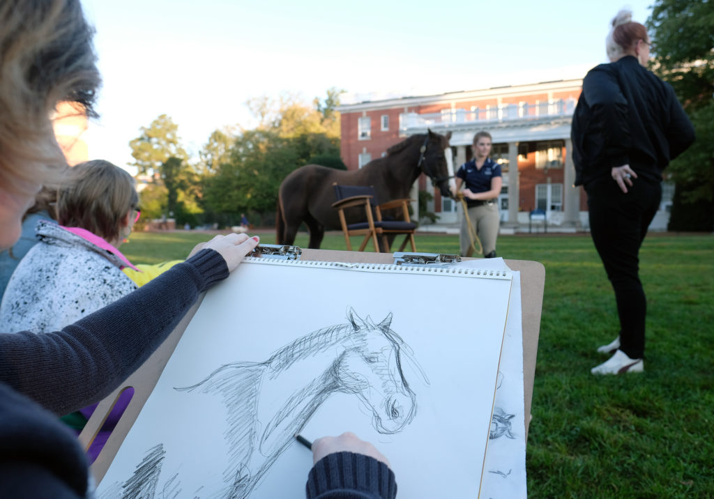 Led by Associate Professor of Art and Art History Rosemary Jesionowski, UMW students sketch one of the equestrian team’s horses on Ball Circle. 