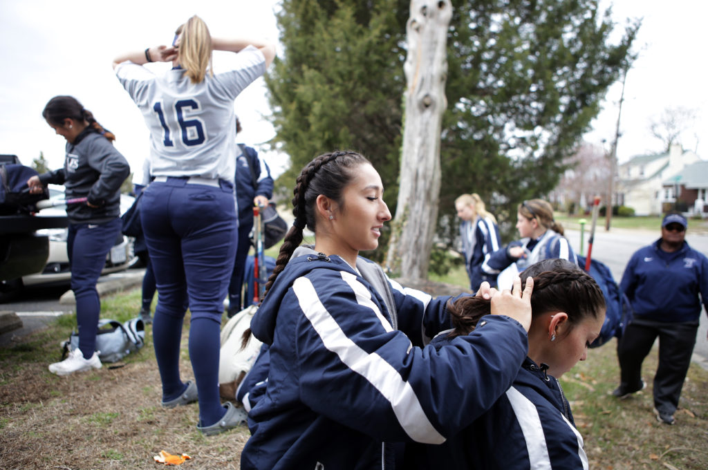 Senior Malia Rogers braids her teammate’s hair as they wait for the rest of the team to arrive.