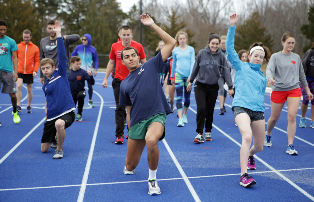 Long-distance athletes warm up on the university’s track and field complex before a practice run.