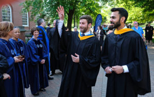 Davis, left, and Haider share a light moment with faculty before the procession.