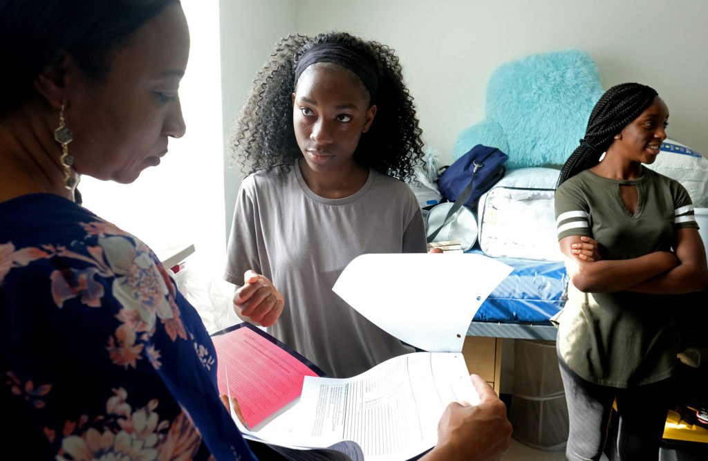 Valerie Ebenki looks over some paperwork with her mom, Elenour in Randolph Hal. At right is Valerie's best friend Lydia Fozo. (Photo by Norm Shafer).