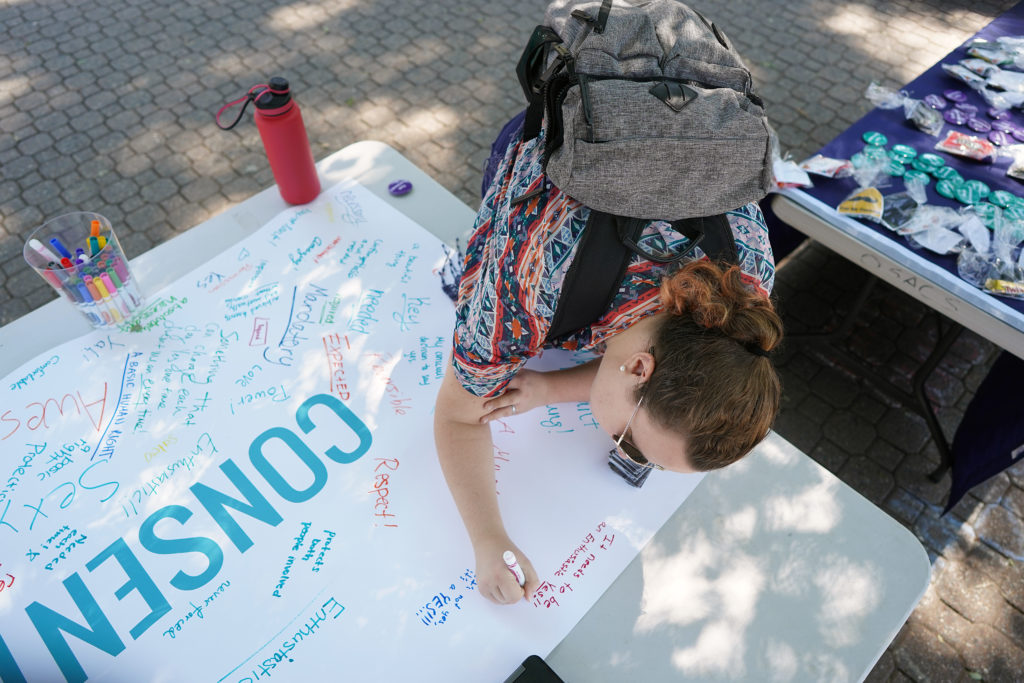 UMW student Ariana Dodge signs the banner for the Office of Title IX's "consent campaign." The initiative is one of several UMW has implemented to increase awareness of sexual assault. Photo by Suzanne Rossi.