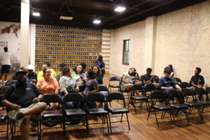 UMW students sit inside the Legacy Museum in Montgomery. Behind them are jars filled with soil from the ground where African-Americans were lynched throughout the country.