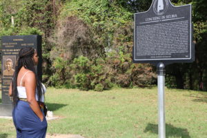 UMW student Brianna Reaves reads a sign that tells of repeated lynchings in Selma, Alabama, which took place well into the 20th century. Thousands of African-American men, women and children were lynched across the country.