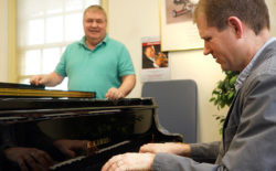 Brooks Kuykendall plays one of UMW's new Kawai pianos while Doug Gately looks on.