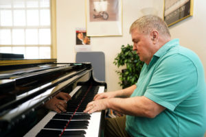 Doug Gately, senior lecturer and director of the UMW Jazz Ensemble plays one of the eight new Kawai pianos that were delivered to UMW this week. Photo by Suzanne Carr Rossi.