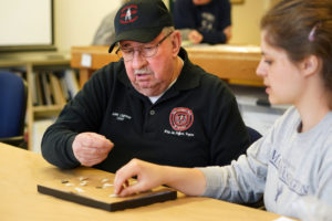 John Lightner, chief emeritus of the Stafford County-based Patawomeck Indian tribe, examines projectile points found at Aquia Creek with UMW sophomore Abigail Phelps. Photo by Suzanne Carr Rossi.