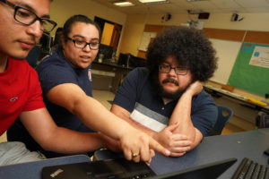 “I wanted to be more productive in my free time," said 18-year-old Daniel Hernandez (left), who feels that getting his GED will help him find better opportunities. Here, he gets help preparing to take the math test from UMW junior Salma Sandoval (center) and Tristen Mimiaga, a JMHS Spanish teacher (right). Photo by Suzanne Rossi.