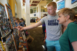 Chris Fols (left) shows his mom, Wendy Fols, jewelry for sale. Photo by Suzanne Carr Rossi.