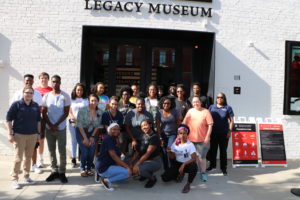 Mili Mehari (front row, far right) poses with UMW students who joined the first-ever Fall Break Social Justice trip to Alabama stand in front of the Legacy Museum in Montgomery. Mehari played an important role in making the trip possible, including securing funds.