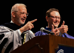 President Troy Paino, left, and CAS Dean Keith Mellinger cheer on the graduates. Photo by Clement Britt