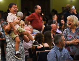 Liam Skinner laughs as his father, Chris Skinner, enters Dodd Auditorium at the start of the UMW Graduate School graduation ceremony.