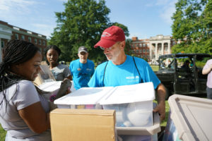 President Troy Paino helps a freshman and her family move her personal belongings into her residence hall. Photo by Suzanne Rossi.