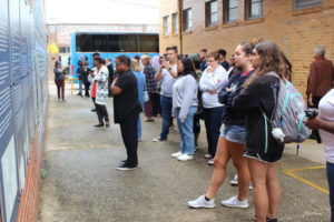 Students and community members reflect on the Freedom Riders' courage, conviction and character at the Anniston, Alabama bus bombing site. Above the mural depicting the Greyhound bus the riders rode are the words, "Could You Get On The Bus?" Photo by Lynda Allen.