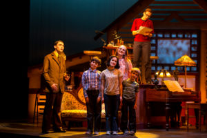 Adult Alison (played by Olivia Whicheloe '19, background), observes her younger self with her father, mother and brothers in a childhood memory. Foreground, from L-R: Bruce (Max Kingston), Christian (Aidan Caffrey), Alison (Madison Neilson '20), Helen (Rachel Williamson '20) and John (Lachlan Eaton). Photo by Geoff Greene.