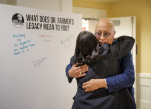 James Farmer Multicultural Center Director Marion Sanford hugs Xavier Richardson at the launch of UMW's Farmer Legacy 2020 celebration. Attendees were asked to sign boards asking the question, "What does Dr. Farmer's legacy mean to you?" Photo by Tom Rothenberg.