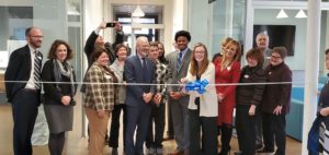 The ribbon is cut during the Willard Hall dedication. The group includes BOV members and student representatives, along with Assistant Dean of Residence Life and Housing Dave Fleming and BOV Rector Heather Mullins Crislip '95 (far left), UMW President Troy Paino (front) and senior Maggie McCotter (with scissors). Photo by Jeff McClurken.