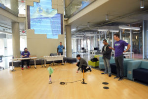 Joshua He, 15, (left) and Mohamed Messouak, 17, (right) listen to the event supervisor for the Ping Pong Parachute competition. Other events included Ornithology, The Sounds of Music, and Elastic Launched Gliders. Photos by Suzanne Carr Rossi.