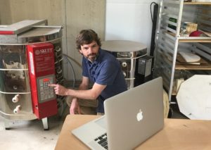 Jon McMillan, associate art professor and chair, teaches ceramics students how to fire an electric kiln using a video chat from his home studio.