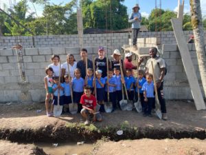 SHH staff and volunteers and Honduran children breaking ground on the nonprofit's 58th school. Construction has since halted on this and other projects. Photo courtesy of SHH.
