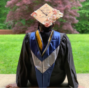 2020 graduate Danielle Norris shows off her graduation gown and decorated mortarboard on UMW's campus.