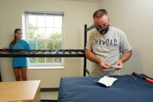 First-year student Sophia Carr of Alexandria works with her father, Jeff, to assemble a bed in her UMW residence hall. Photo by Suzanne Rossi.