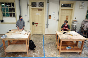 Juniors Katie Ragone (left) and Rebecca Visger (right) chat from their respective workstations during a socially distanced sculpture class in Melchers Hall. Photo by Suzanne Carr Rossi.