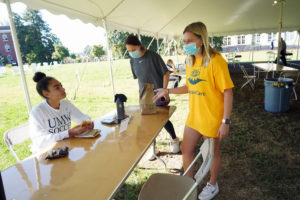 Eagles Care Ambassador Anna Longacher (in yellow) works a shift in a dining tent on Ball Circle. Student ambassadors remind others to follow COVID-19 guidelines. Photo by Suzanne Carr Rossi.